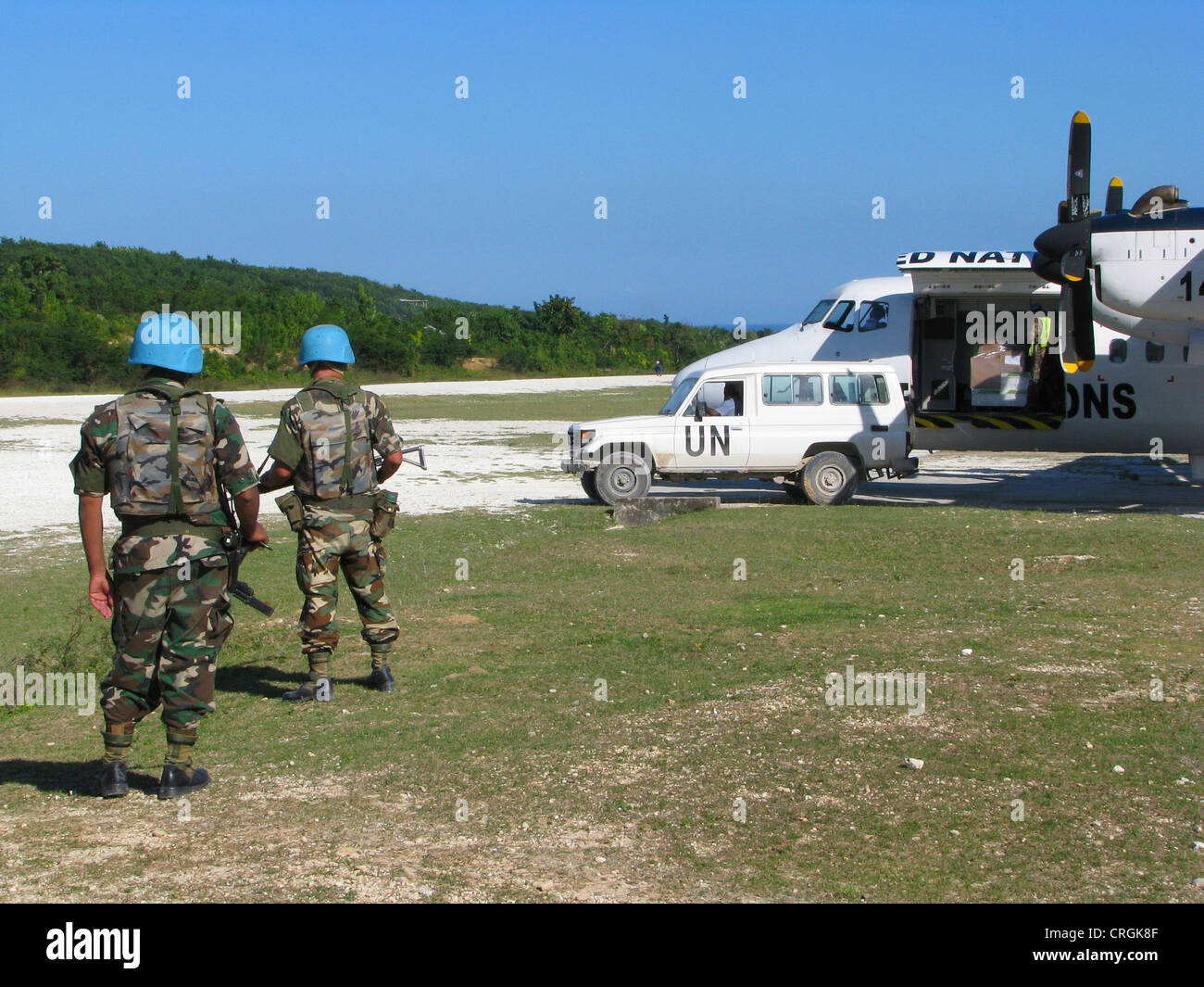 Soldaten der "Mission der Vereinten Nationen Stabilisierung in Haiti" sichern UN Flugzeuge mit Maschinengewehr und Sturmgewehr neben unbefestigten Piste, Haiti, Grande Anse, Jeremie Stockfoto
