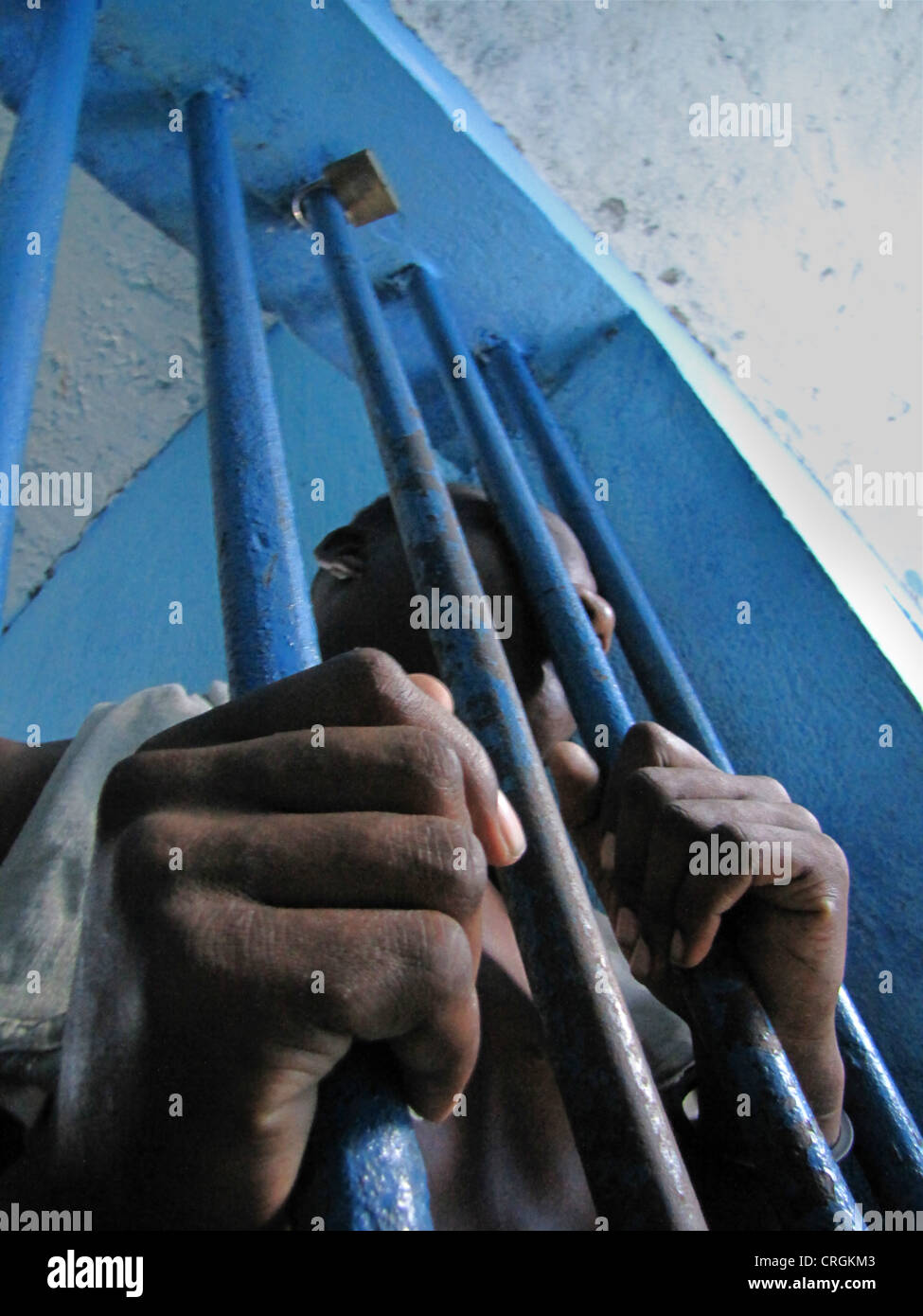 Häftling hinter Gittern eines Fensters in heruntergekommenen predetention Zelle (Garde Vue) bei Polizei, Kommissariat von J R Mie, Haiti, Grande Anse, Jeremie Stockfoto