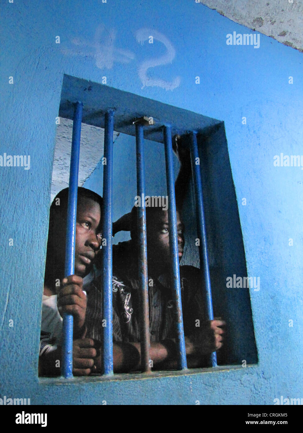 Häftlinge hinter Gittern eines Fensters in heruntergekommenen predetention Zelle (Garde Vue) bei Polizei, Kommissariat von J R Mie, Haiti, Grande Anse, Jeremie Stockfoto