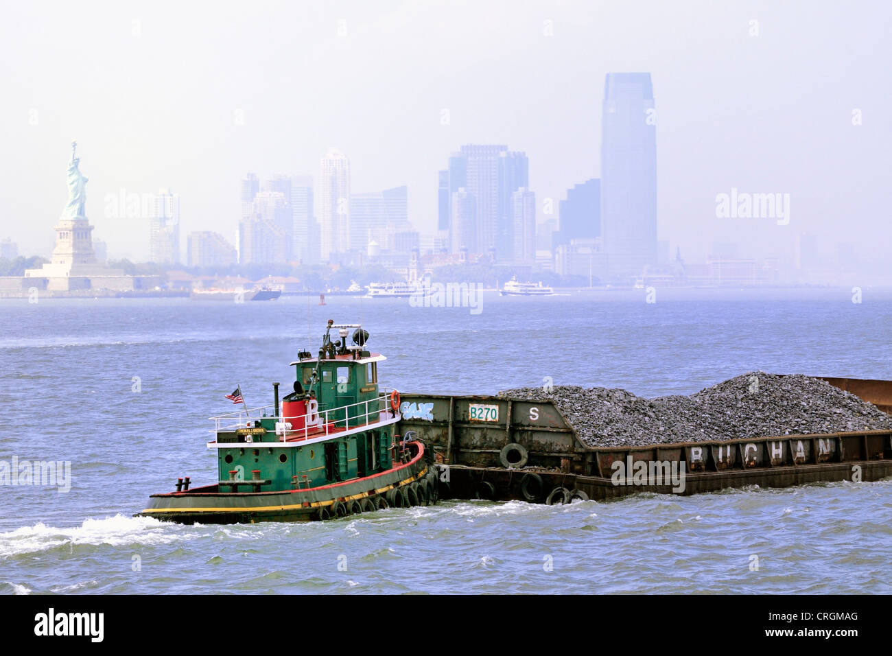 Der Schlepper Thomas J. Brown führt eine gefüllte Barkasse durch den Hafen von New York Stockfoto