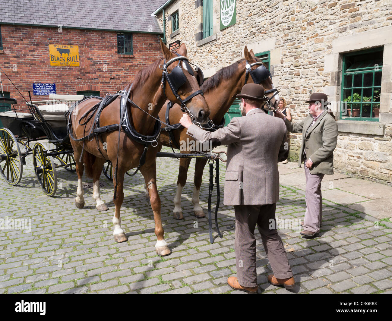 Männliche und weibliche Bräutigam mit Wagen und Pferden in der Stadt Stallhof Beamish Museum of Northern Life Stockfoto