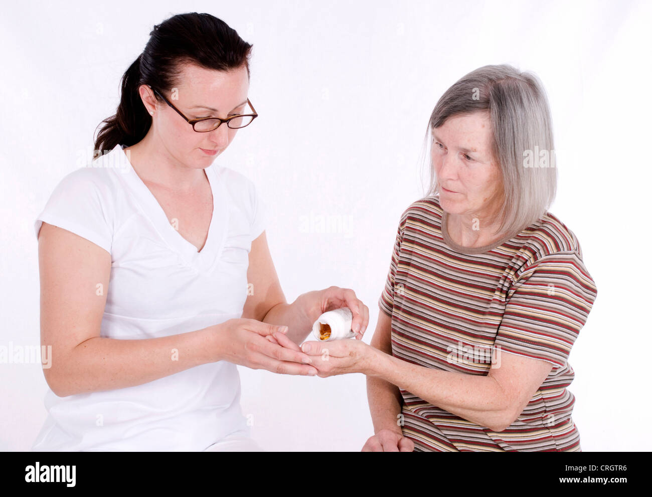 ältere Frau bekommt Pillen von älteren Menschen Brustschwester Stockfoto