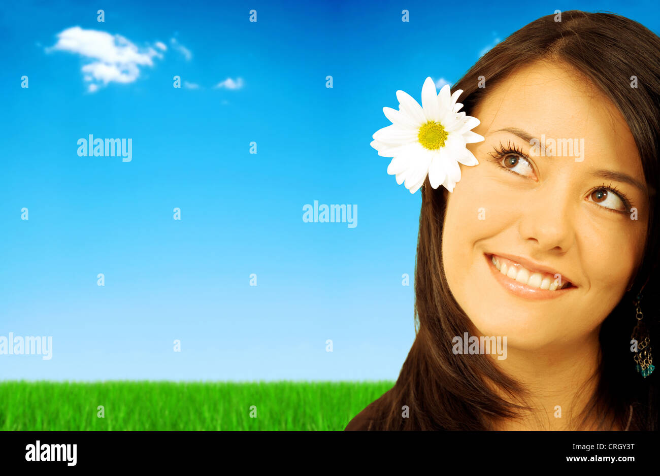 schönen Frühling oder Sommer Mädchen lächelnd im Freien - sie hat eine weiße Daisy Blume auf dem Kopf und hat eine durchdachte und ausdrucksstarke Gesicht Stockfoto