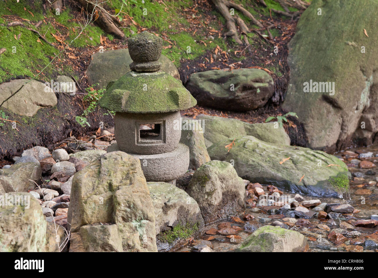 Kleinen Stein Stupa am Ufer eines Baches in der traditionellen japanischen Nitobe Memorial Garden. Stockfoto