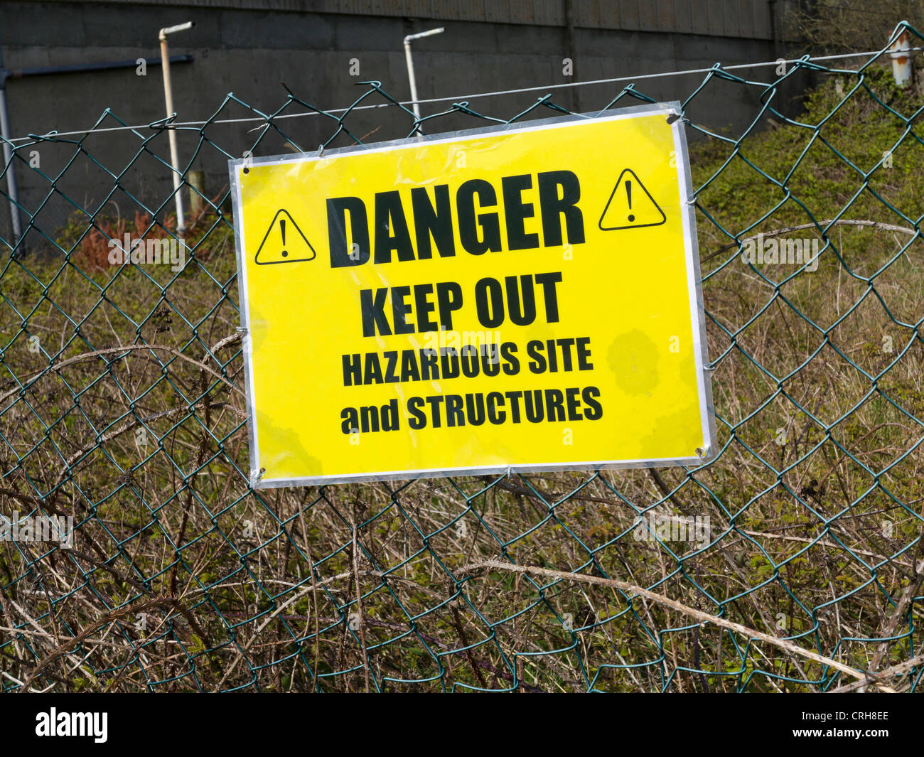 Halten, Warnschild außerhalb einer verlassenen Fabrik komplexe Stockfoto