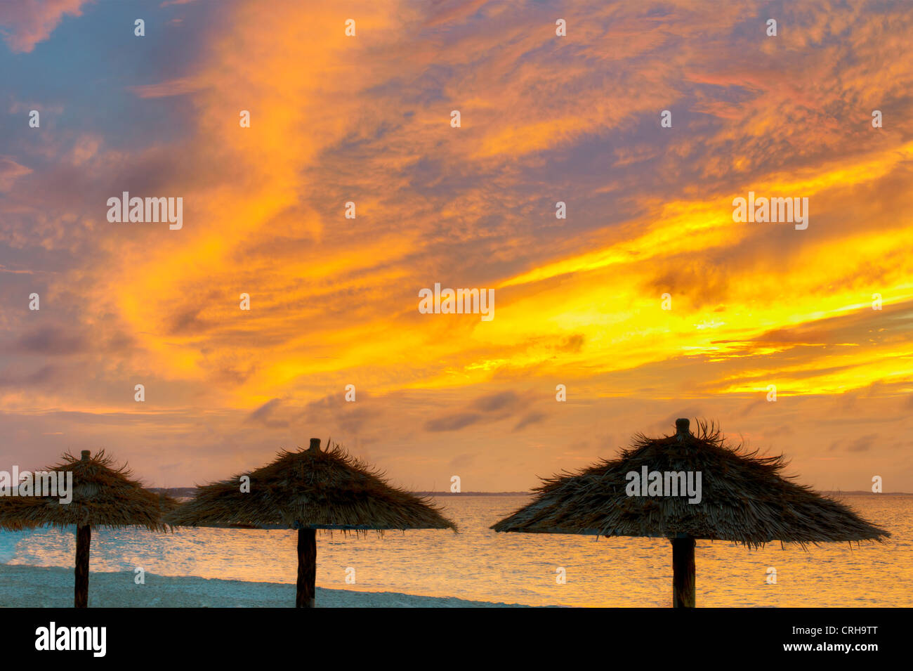Reed Umbellas am Strand bei Sonnenuntergang im Grace Bay. Providenciales. Turks- und Caicosinseln. Stockfoto