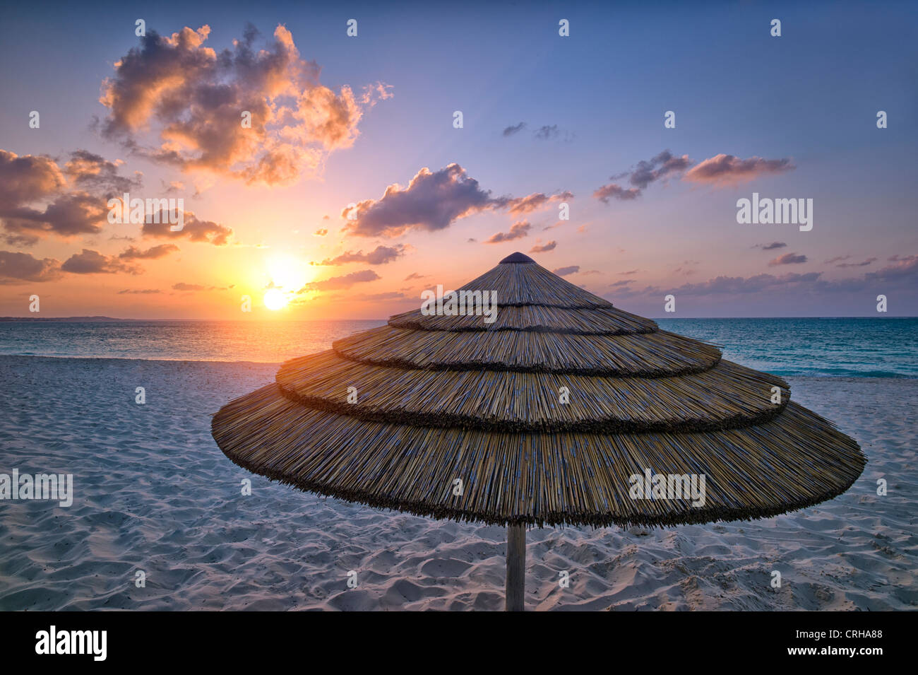 Reed-Schirm und Sonnenuntergang. Grace Bay. Providenciales. Turks- und Caicosinseln. Stockfoto