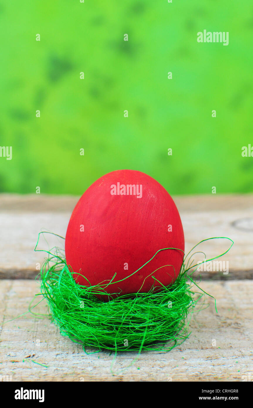 Rote Ostereier im Nest auf grünem Hintergrund Stockfoto