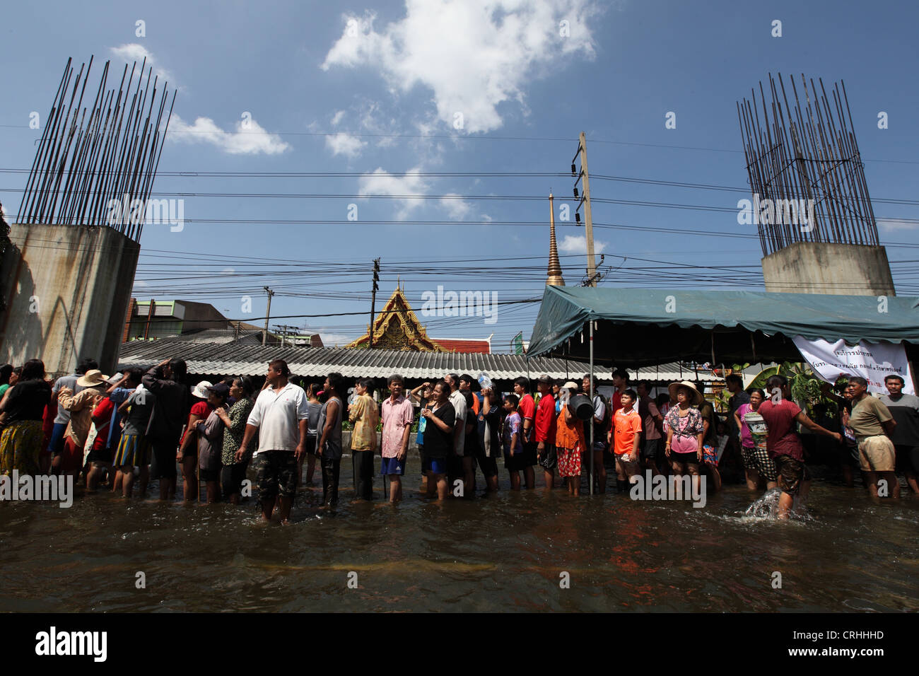 Menschen richten, Nahrung und Wasser Ration erhalten, da Überschwemmungen Bereich Don Muang in Bangkok zu verwüsten. Stockfoto
