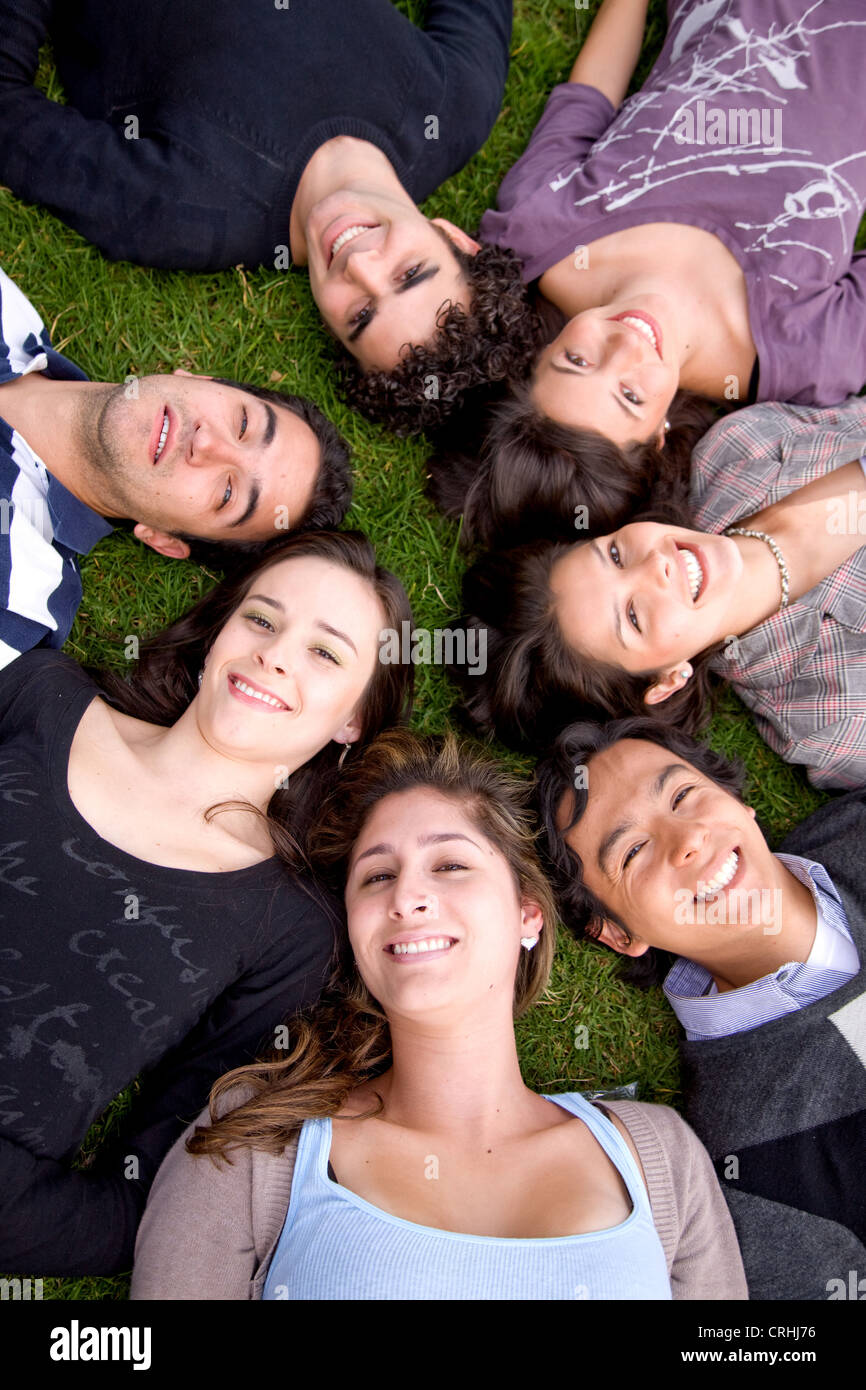 Gruppe von Freunden, die Kopf an Kopf liegen auf dem Rasen Stockfoto