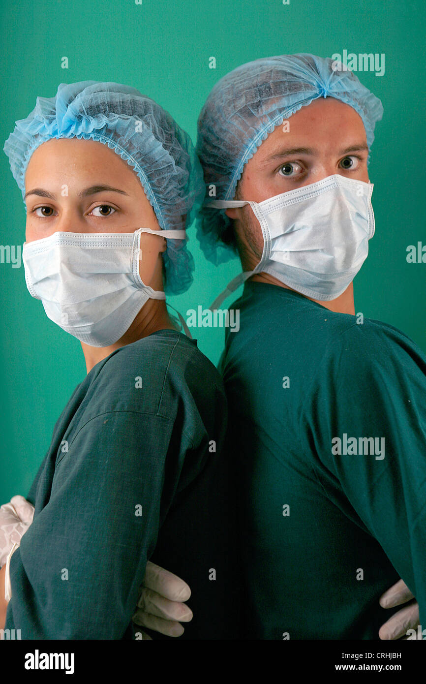 Zwei maskierte Chirurgen vor der Kamera mit ihren Armen gekreuzt. Stockfoto