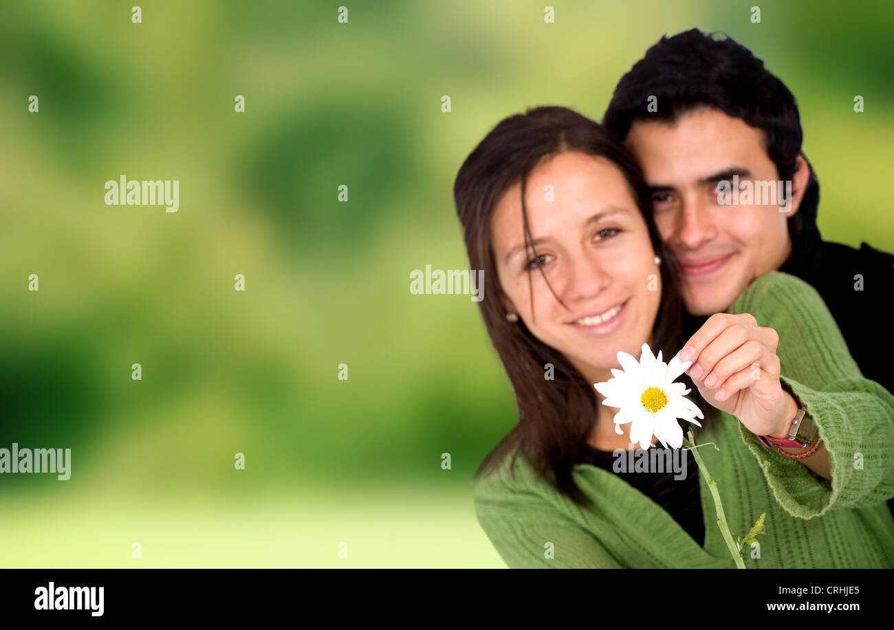 paar in der Liebe mit einer Daisy Blume im Freien in einem Park mit einem grünen Hintergrund Stockfoto