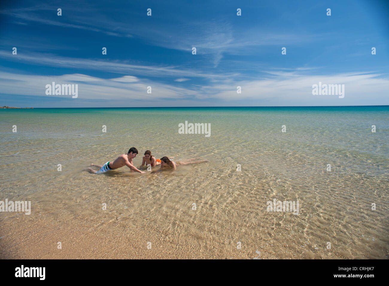 Freunde spielen in der Brandung am Strand Stockfoto