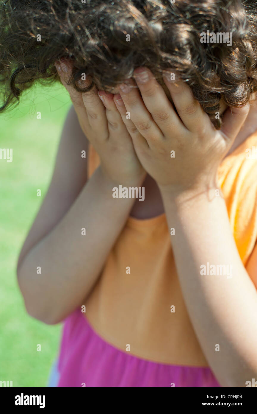 Mädchen-Abdeckung-Gesicht mit Händen Stockfoto