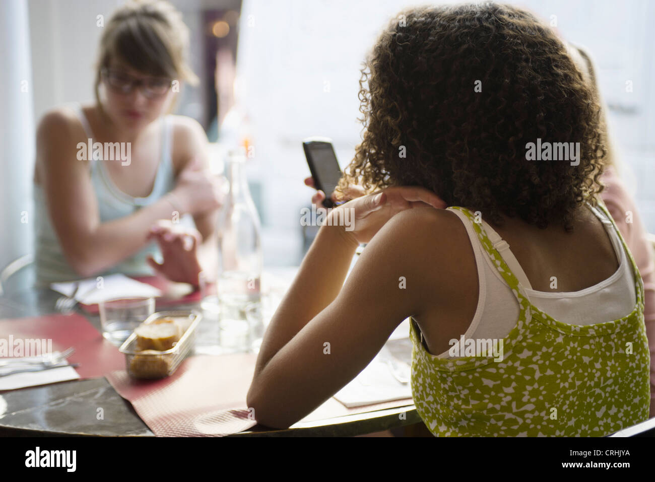 Junge Frau Textnachrichten im Café, Rückansicht Stockfoto