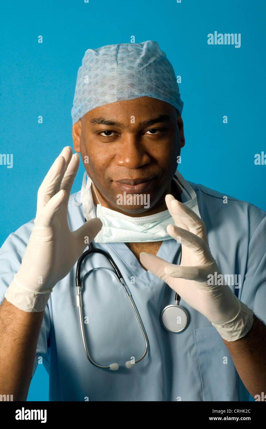 Ein Chirurg mit seinen Händen in der Luft tragen von Handschuhen und Schutzkleidung Stockfoto