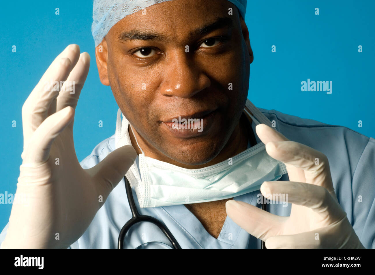 Ein Chirurg mit seinen Händen in der Luft tragen von Handschuhen und Schutzkleidung. Stockfoto
