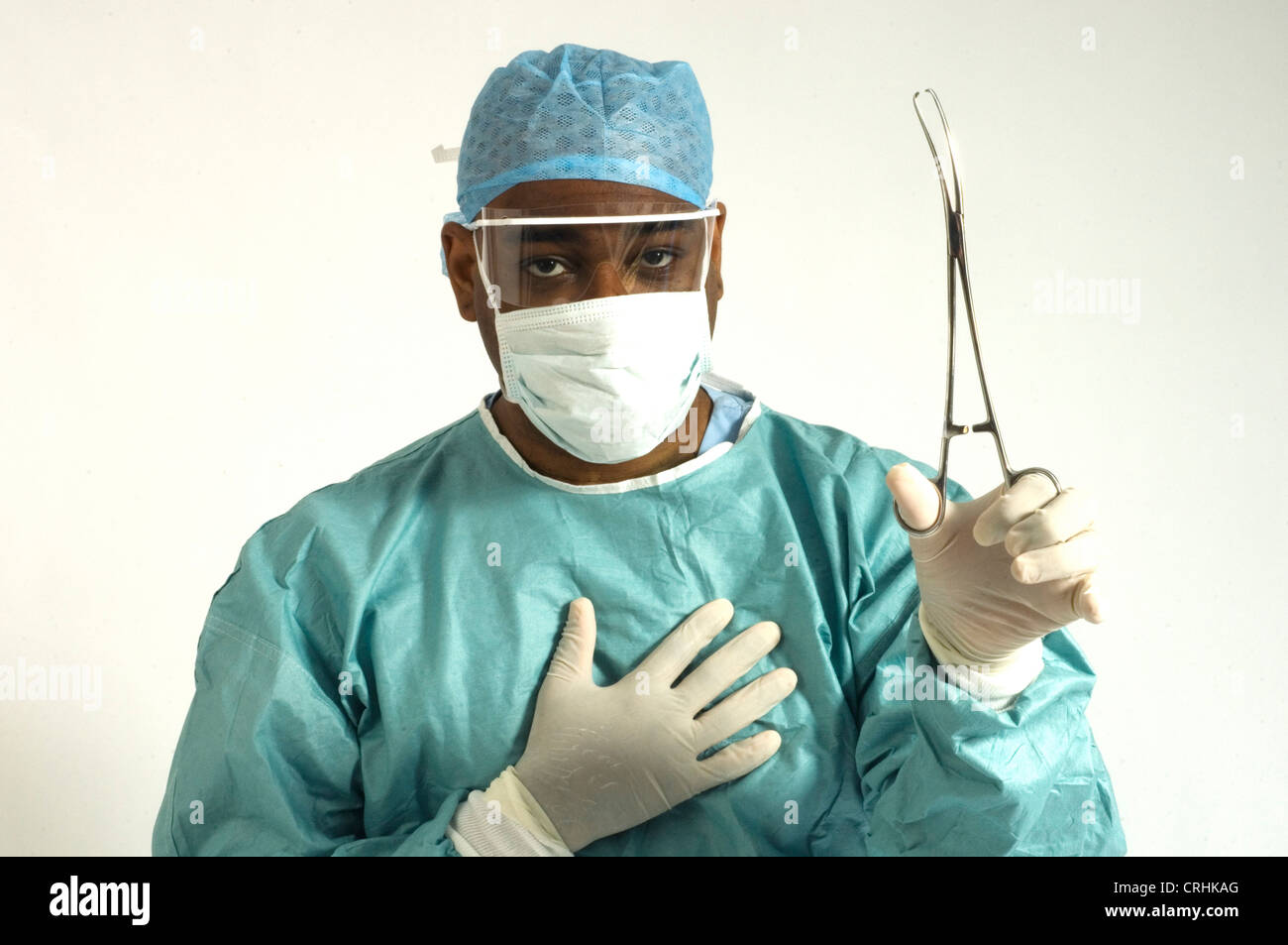 Ein Chirurg, gekleidet in Schutzkleidung mit ein paar Zangen Stockfoto