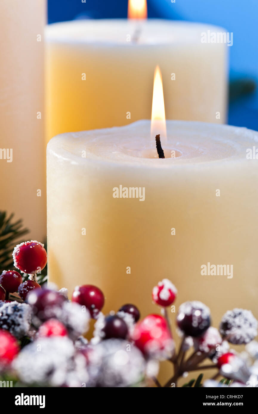 Drei Kerzen vor einem blauen Hintergrund, ein Advent Gesteck für Advent und Weihnachten Stockfoto