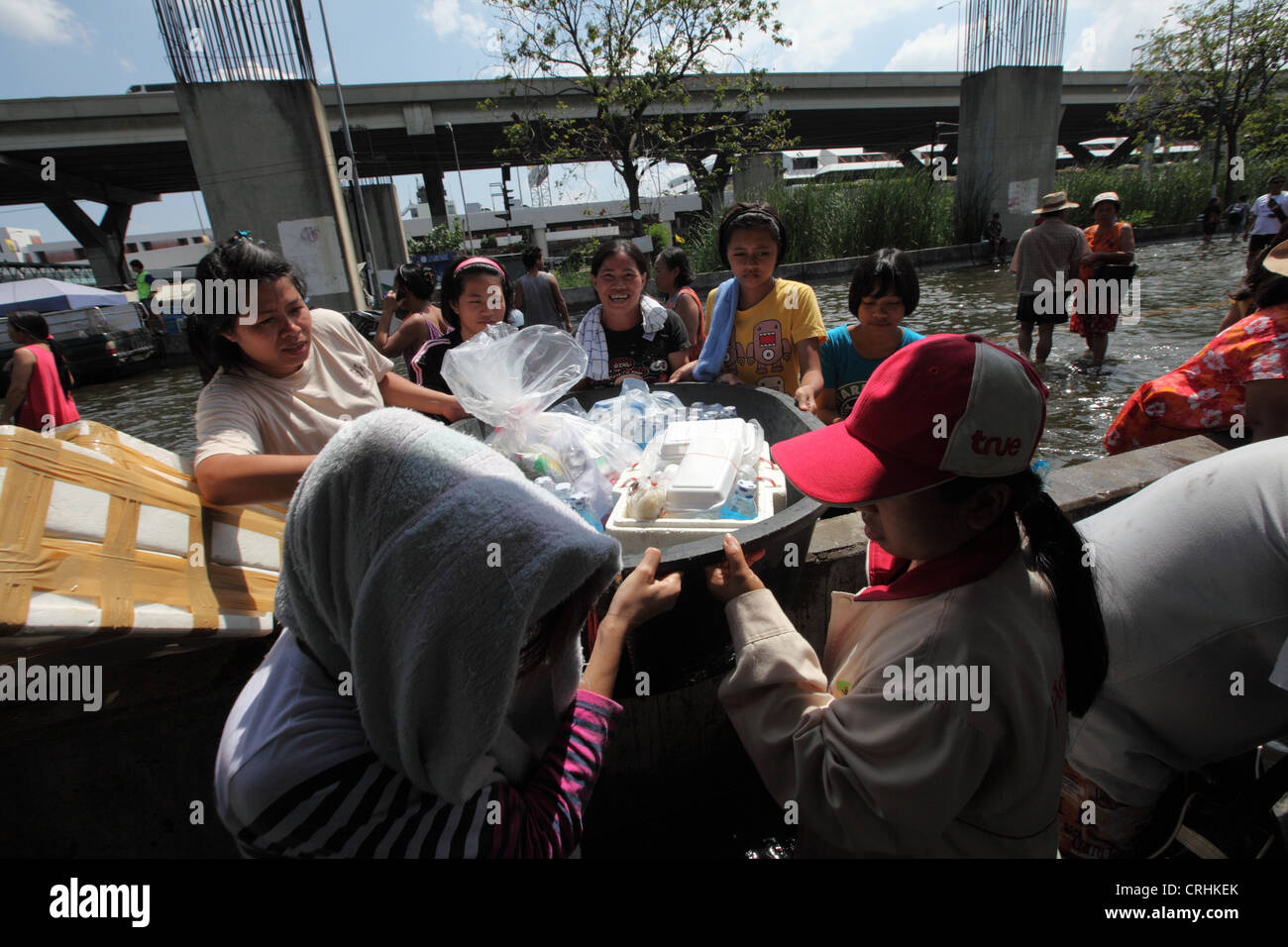 Frauen tragen Nahrung und Wasser rationieren wie Überschwemmungen Bereich Don Muang in Bangkok zu verwüsten. Stockfoto