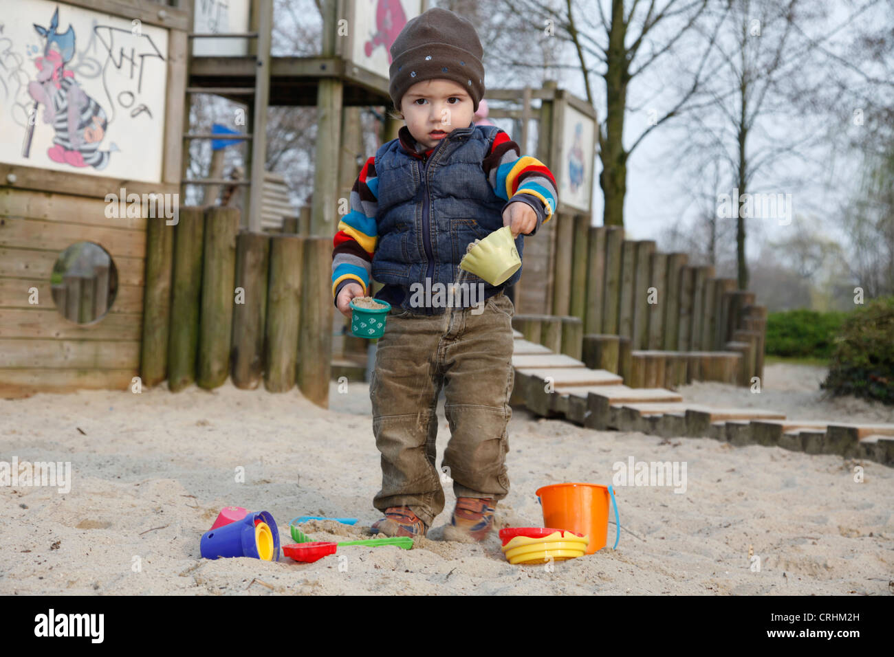 kleiner Junge spielt in einem Sandkasten mit Sand Formen Stockfoto