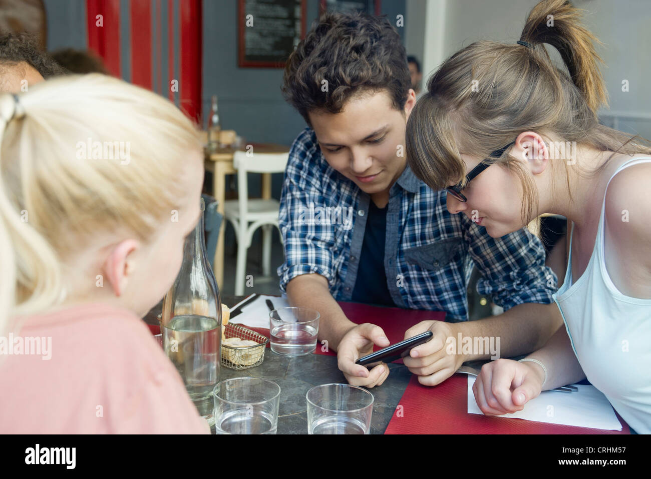 Freunde, die zusammen hängen in Café, Blick auf Handy Stockfoto