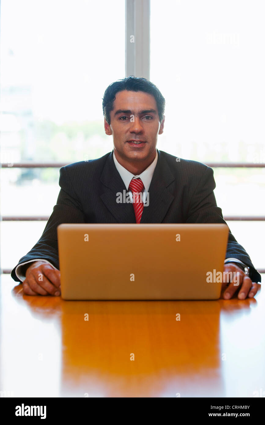 Geschäftsmann, sitzen am Schreibtisch mit Laptop-Computer, Porträt Stockfoto