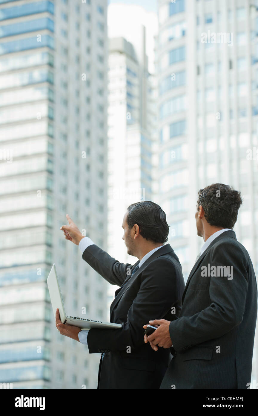 Geschäftsleute mit Laptop-Computer im Freien, ein Mann zeigte in Ferne Stockfoto