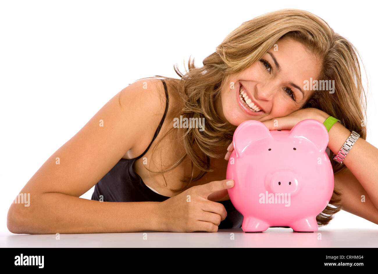 schöne junge Frau liegend den Kopf auf ein rosa Sparschwein glücklich lächelnd Stockfoto
