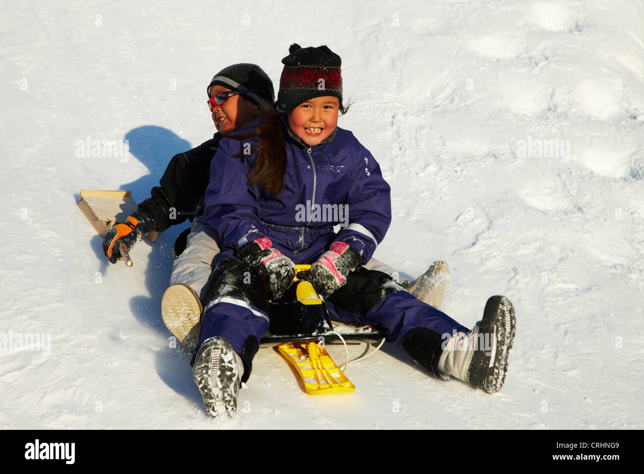 Kinder spielen im Schnee, Grönland, Ostgroenland, Tunu, Kalaallit Nunaat, Scoresbysund, Kangertittivag, Ittoqqortoormiit Stockfoto