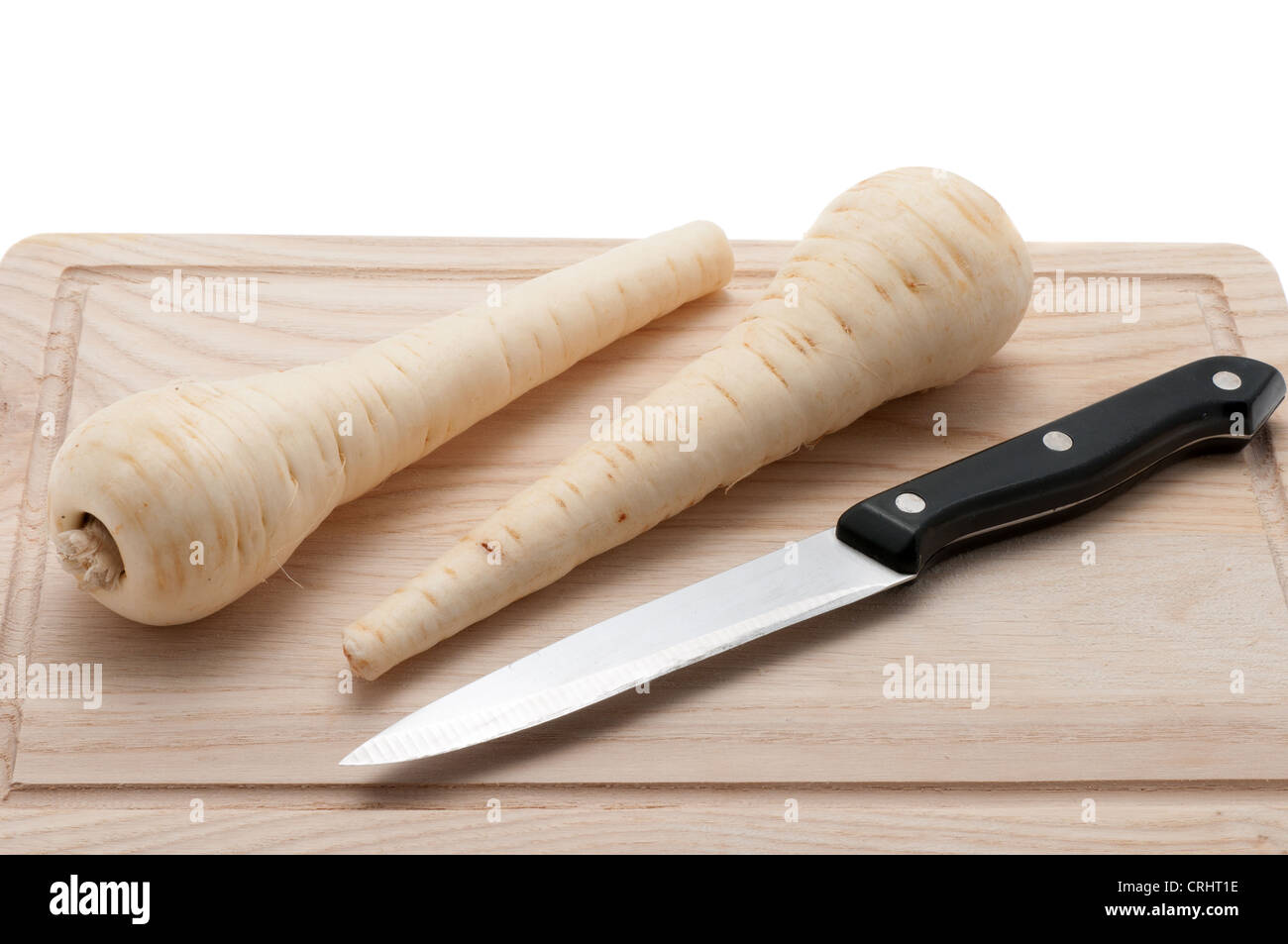 Frische Pastinaken auf einem Holzbrett mit einem Küchenmesser Stockfoto