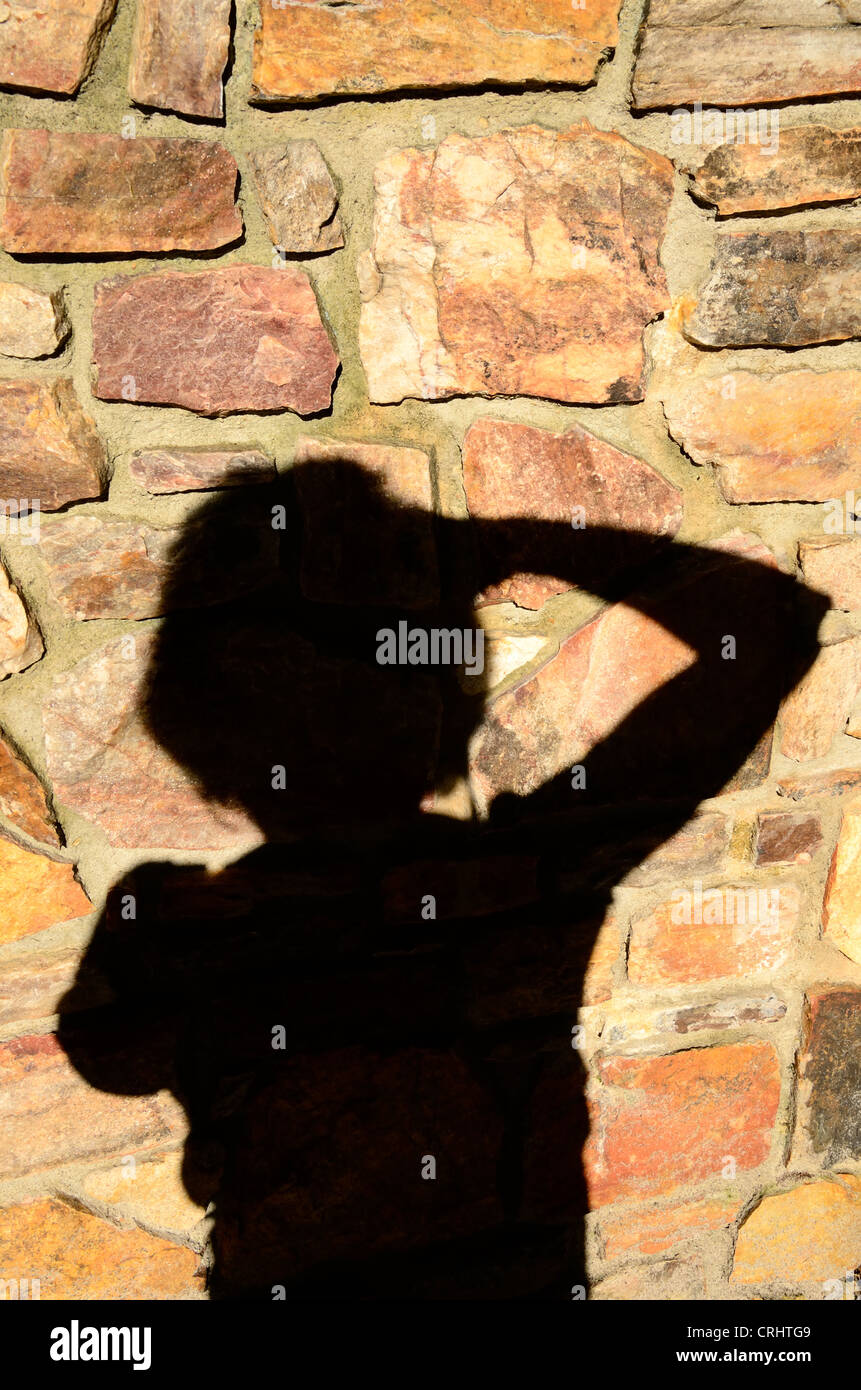 Des Fotografen Schatten auf einer Steinmauer ist vom Fotografen eingefangen. Stockfoto