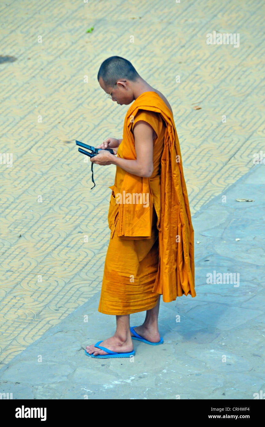 Munk mit zwei Moblie Telefonen in der Strees von Phnom Penh, Kambodscha Stockfoto