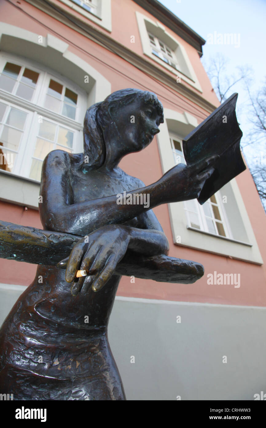 Skulptur von einer Lesung Frau in Fornt einer Bibliothek mit einer Zigarettenpause zwischen den Fingern Stockfoto