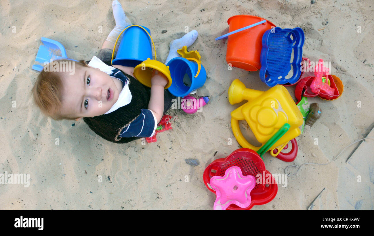 kleiner Junge spielt in einem Sandkasten Stockfoto