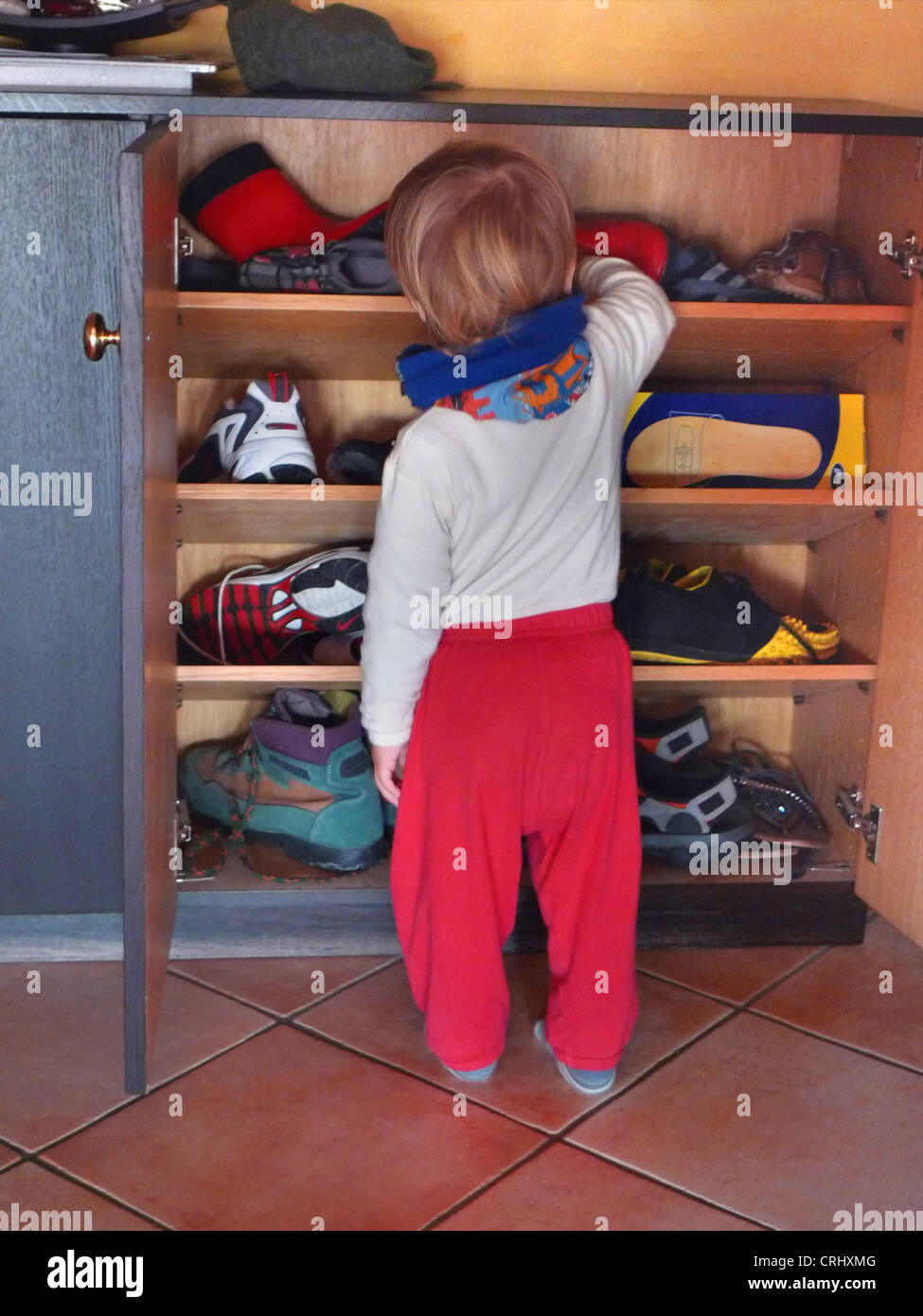 kleiner Junge stand vor einem Schuh Lagerplatz Stockfoto