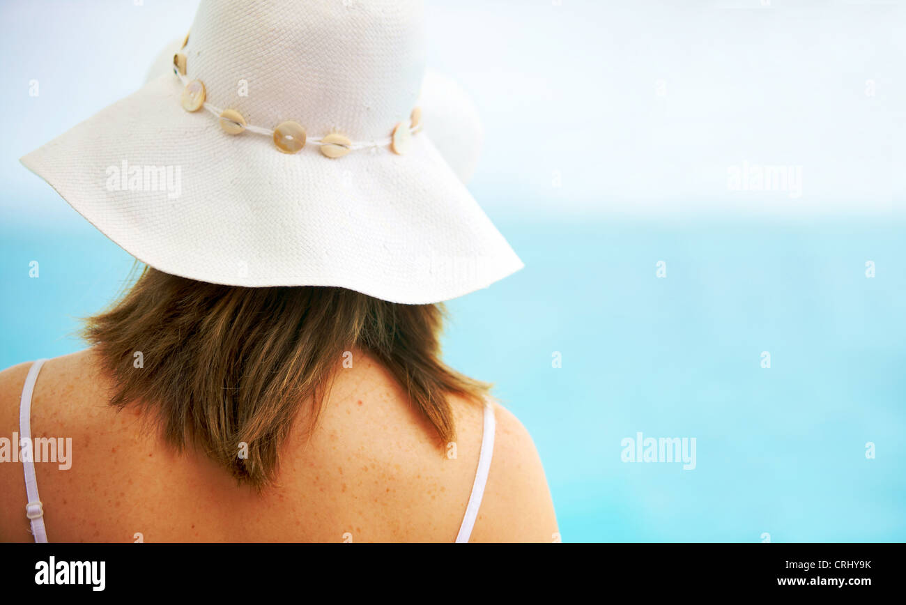 junge Frau trägt eine weiße Sonnenhut am Meer Stockfoto