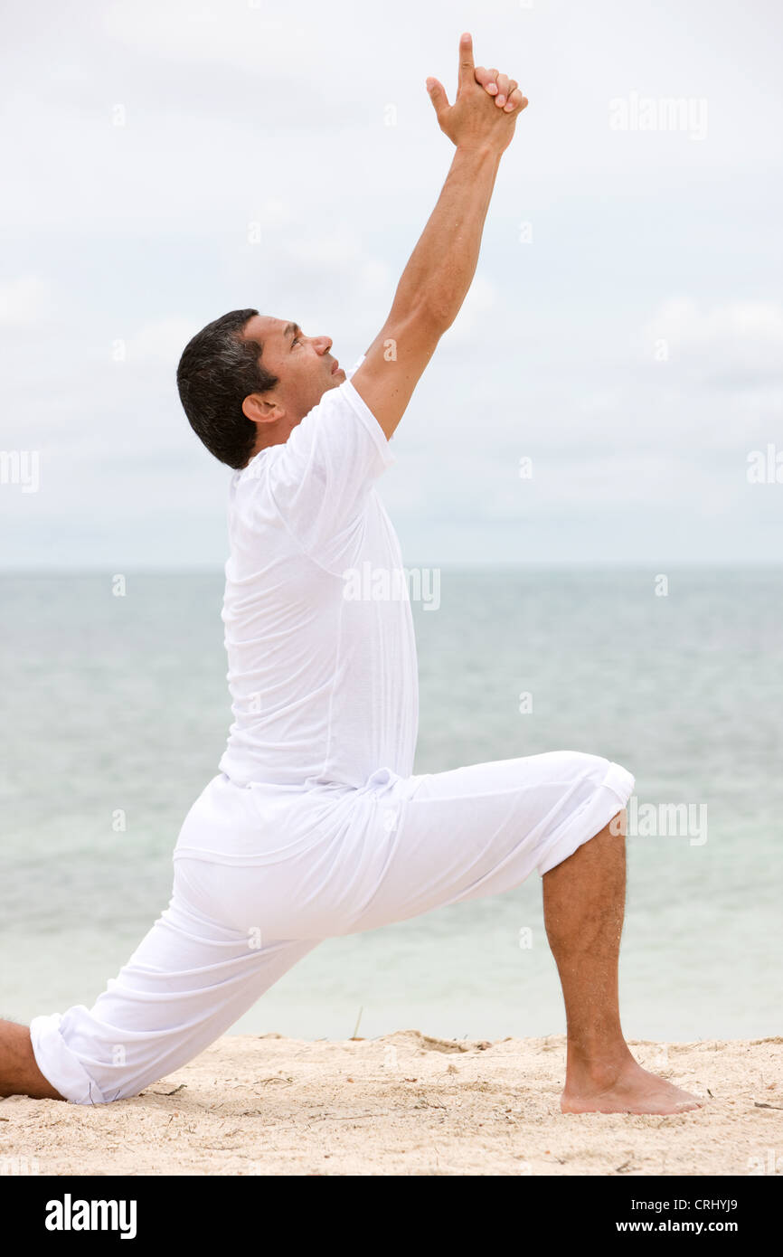 Menschen, die Yoga-Übungen in einer ruhigen Lage am Strand Stockfoto