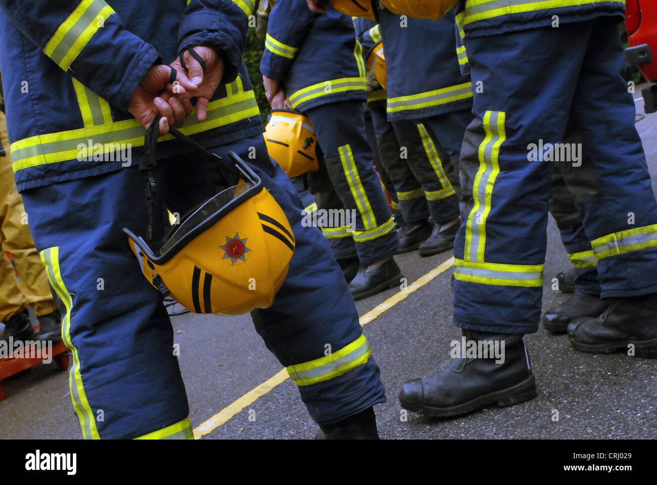 Feuerwehrleute stehen Schlange (Taille abwärts). Stockfoto