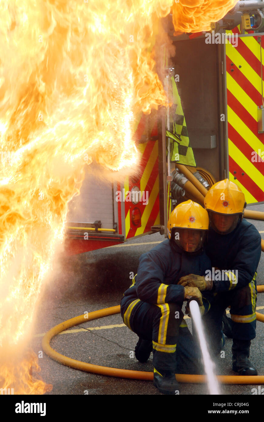 Zwei Feuerwehrleute Aufguss eine Flamme. Stockfoto