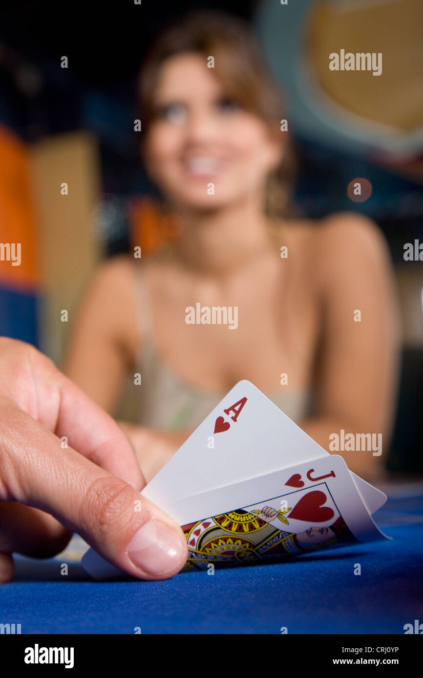 Karte des Spielers Hand Blackjack, weibliche Antagonist immer noch ahnungslos lächelt enthüllt Stockfoto