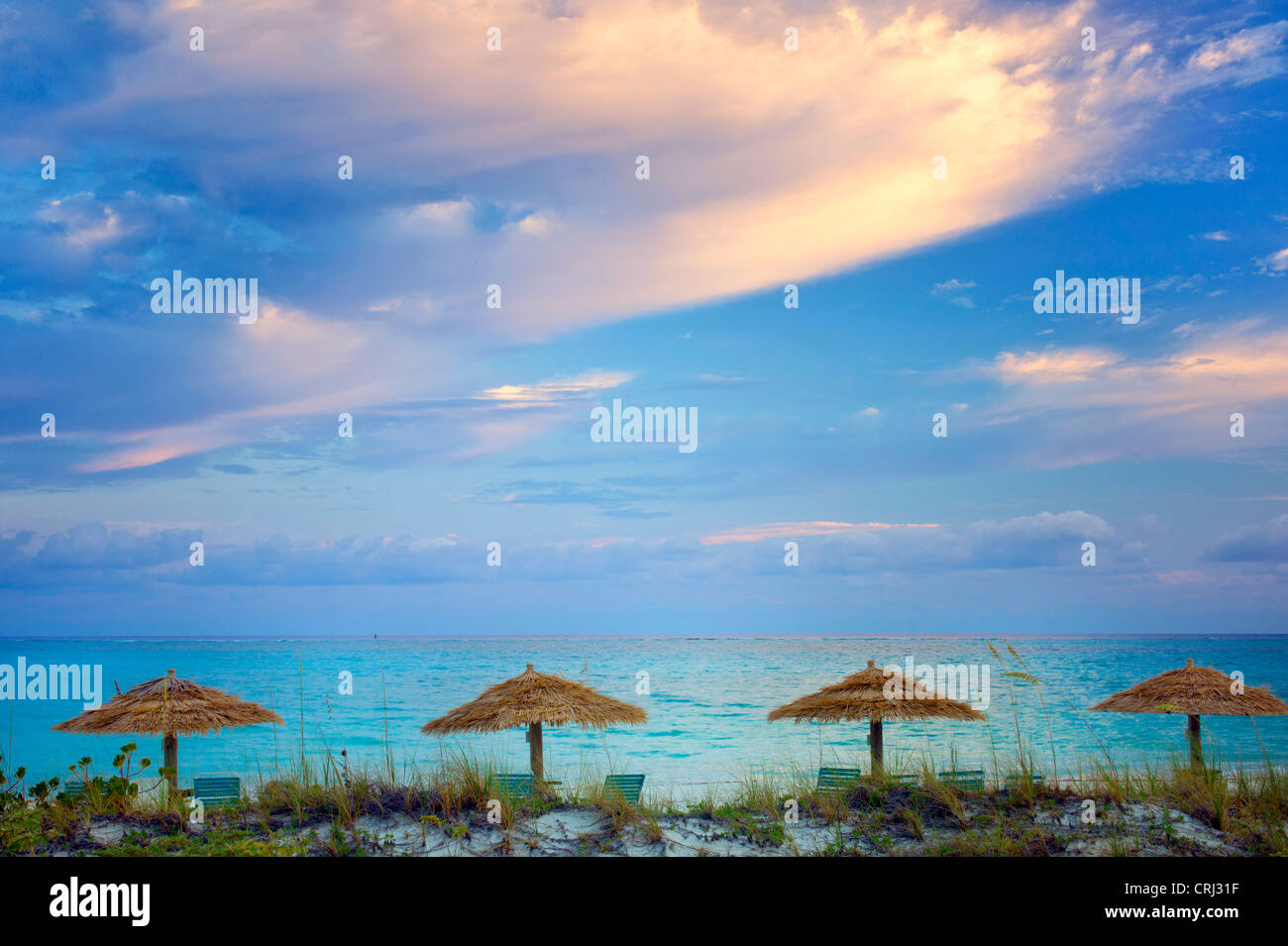 Reed Umbellas und Sonnenaufgang Wolken. Turks- und Caicosinseln. Providenciales Stockfoto