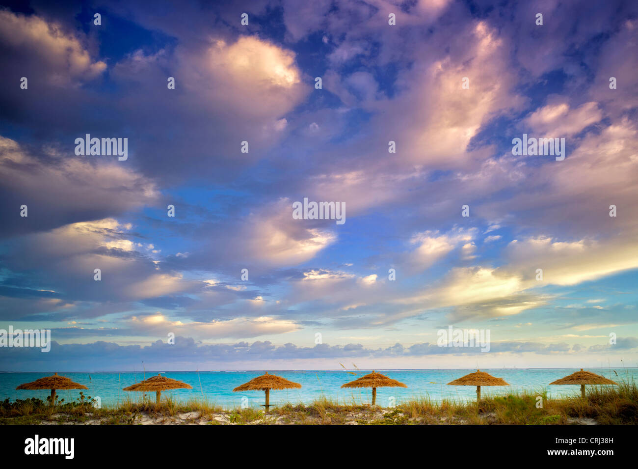 Reed Umbellas und Sonnenaufgang Wolken. Turks- und Caicosinseln. Providenciales Stockfoto