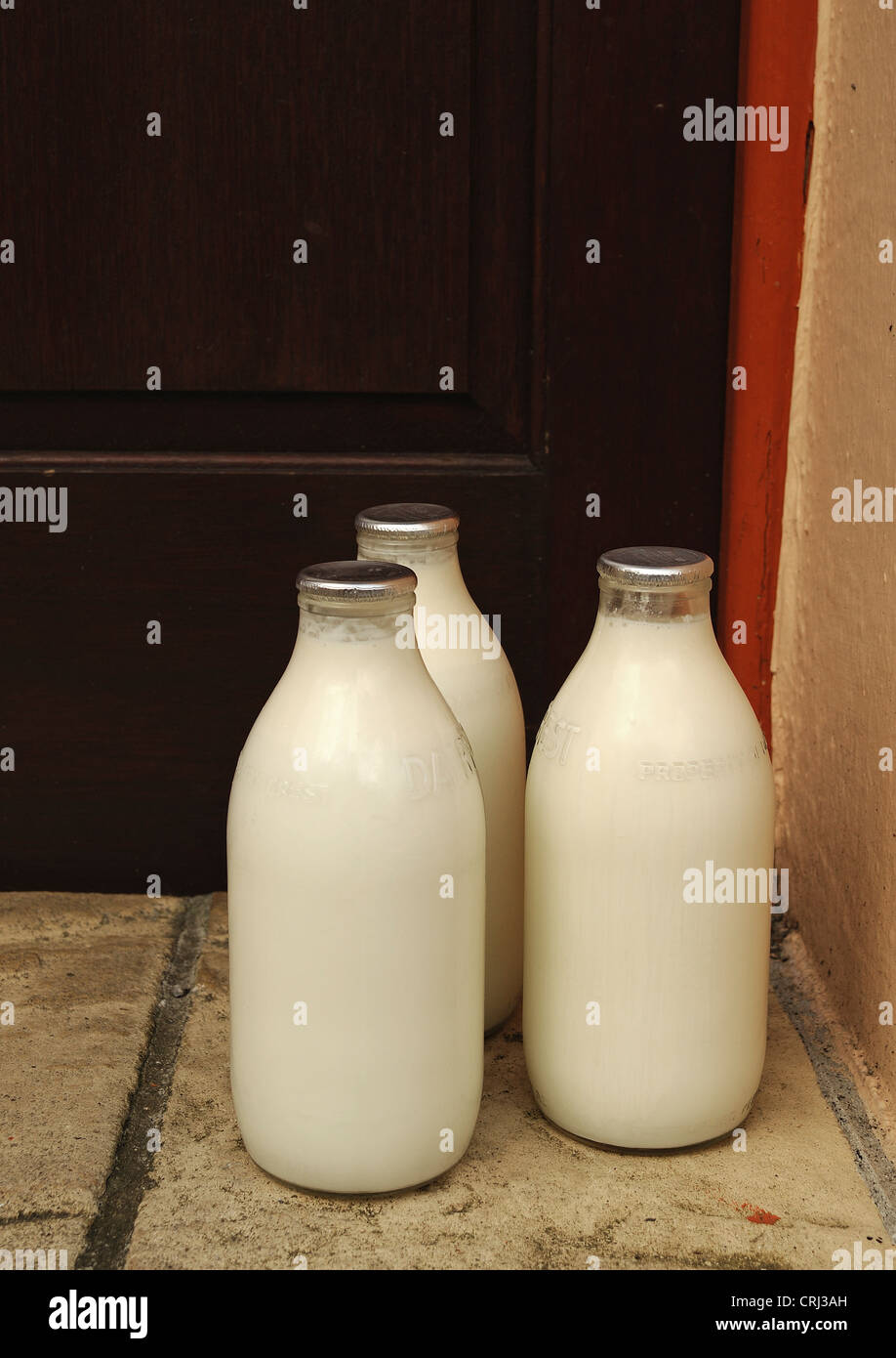 Flaschen Milch vor einer Haustür Stockfoto