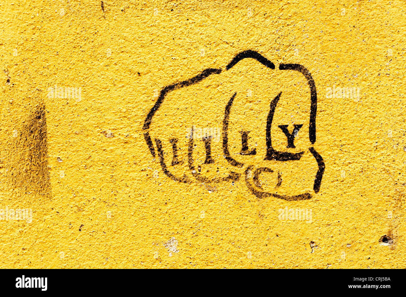 Die Lotnummer Faust auf eine gelbe Wand mit dem Namen Lily auf die Finger. Stockfoto