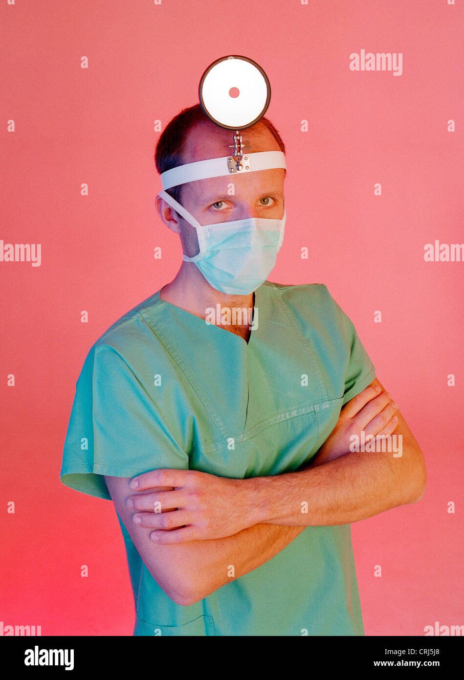 Arzt mit Maske und Spiegel für Untersuchungen im Bereich ENT Stockfoto