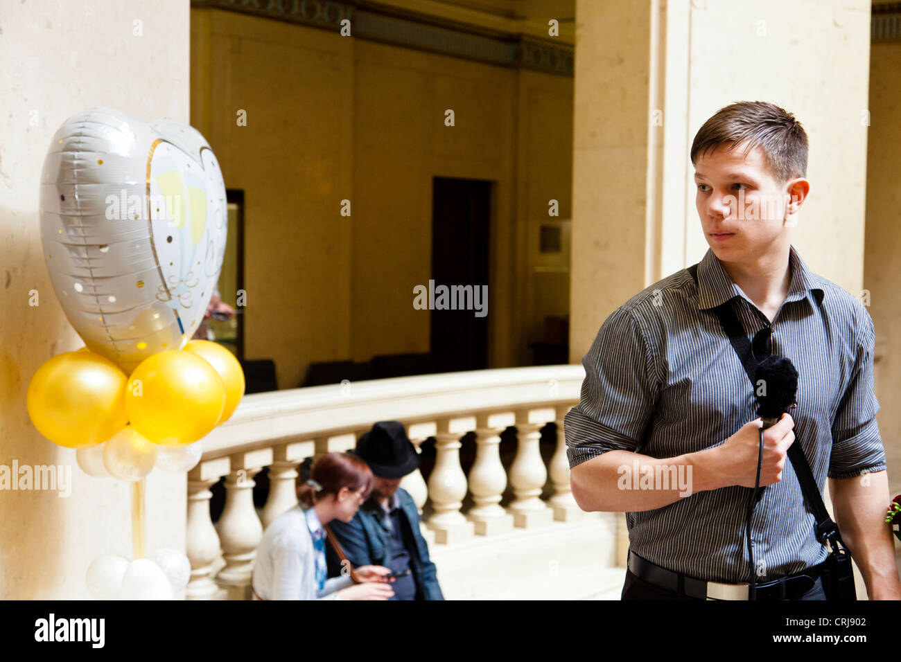 Humorvoll Bild. Junge Journalisten interviewen 'Just Married' Ballon auf einer Hochzeitsmesse, Nottingham, England, Großbritannien Stockfoto