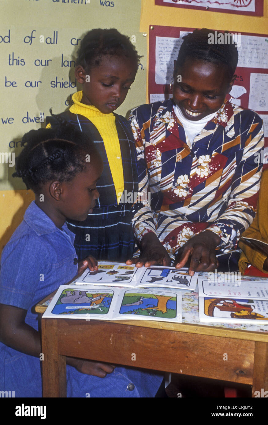 Schwarze afrikanische Dame Grundschullehrerin mit zwei Mädchen Kinder lernen mit Büchern zu lesen öffnen Stockfoto