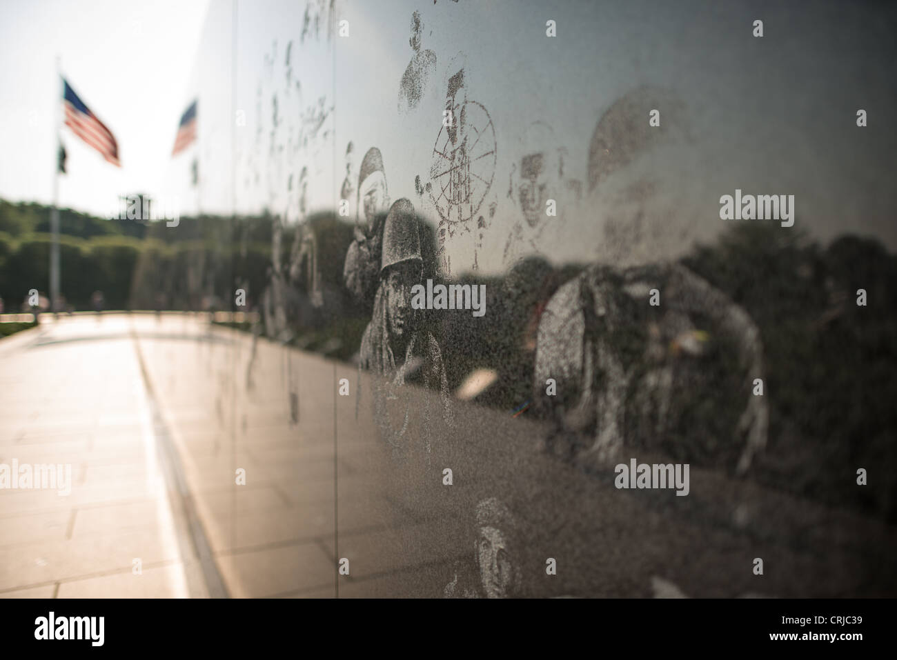 WASHINGTON DC – Fotos, die in die schwarze Granitwand des Korean war Veterans Memorial geätzt sind, zeigen Mitglieder des Militärs, die am Konflikt beteiligt waren. Die Gedenkmauer, die sich über 164 Meter erstreckt, enthält mehr als 2.500 Fotos, die in ihre reflektierende Oberfläche sandgestrahlt wurden. Die amerikanische Flagge markiert die Spitze des dreieckigen Grundrisses der Gedenkstätte. Das 1995 eingeweihte Denkmal ehrt die 5,8 Millionen Amerikaner, die im Koreakrieg von 1950 bis 1953 gedient haben. Das Hotel befindet sich in der National Mall und ist eine feierliche Hommage an diejenigen, die in dem oft als „vergessener Krieg“ bezeichneten gedient haben. Stockfoto