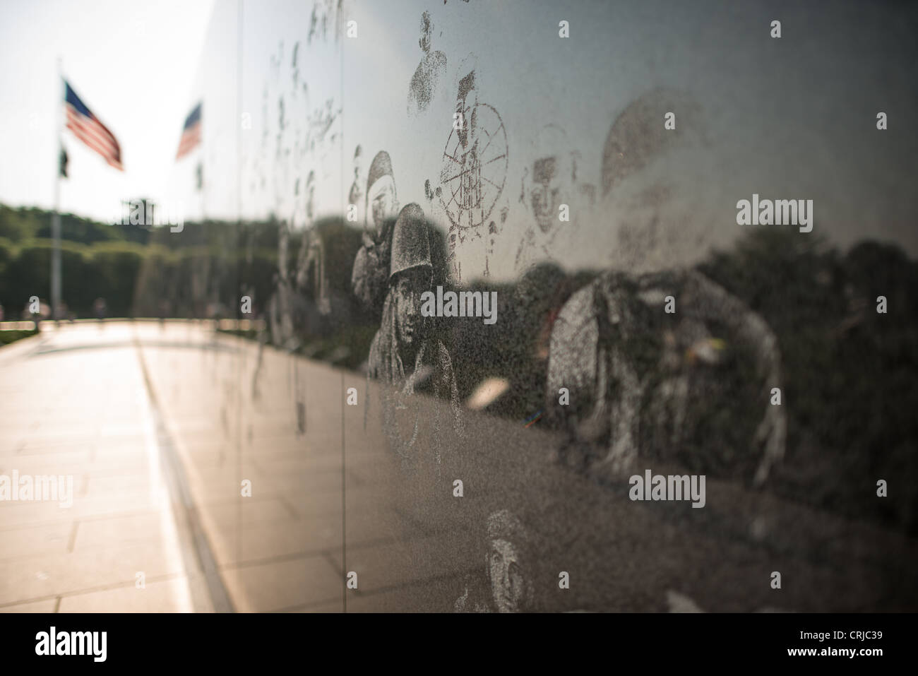 WASHINGTON DC, USA - Korean War Veterans Memorial Wall Radierungen. Auf der rechten Seite sind einige der Radierungen von Veteranen, die im koreanischen Krieg auf der Wand des Korean War Veterans Memorial in Washington DC National Mall serviert. An der weit von Frame links, Unscharf ist die amerikanische Fahne an der Spitze des Dreiecks Form, die Grenzen der Gedenkstätte. Stockfoto